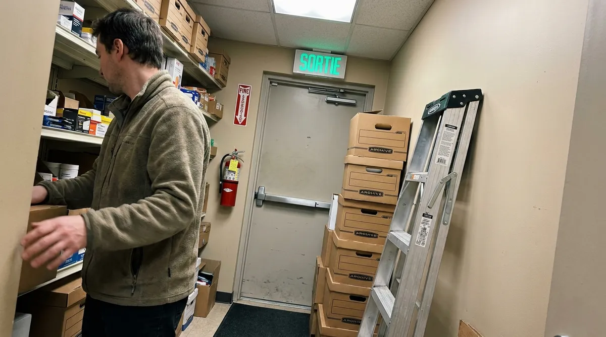 Issue de secours obstruée par des boîtes d'archives dans un bureau, risque à inscrire au plan d'action SST